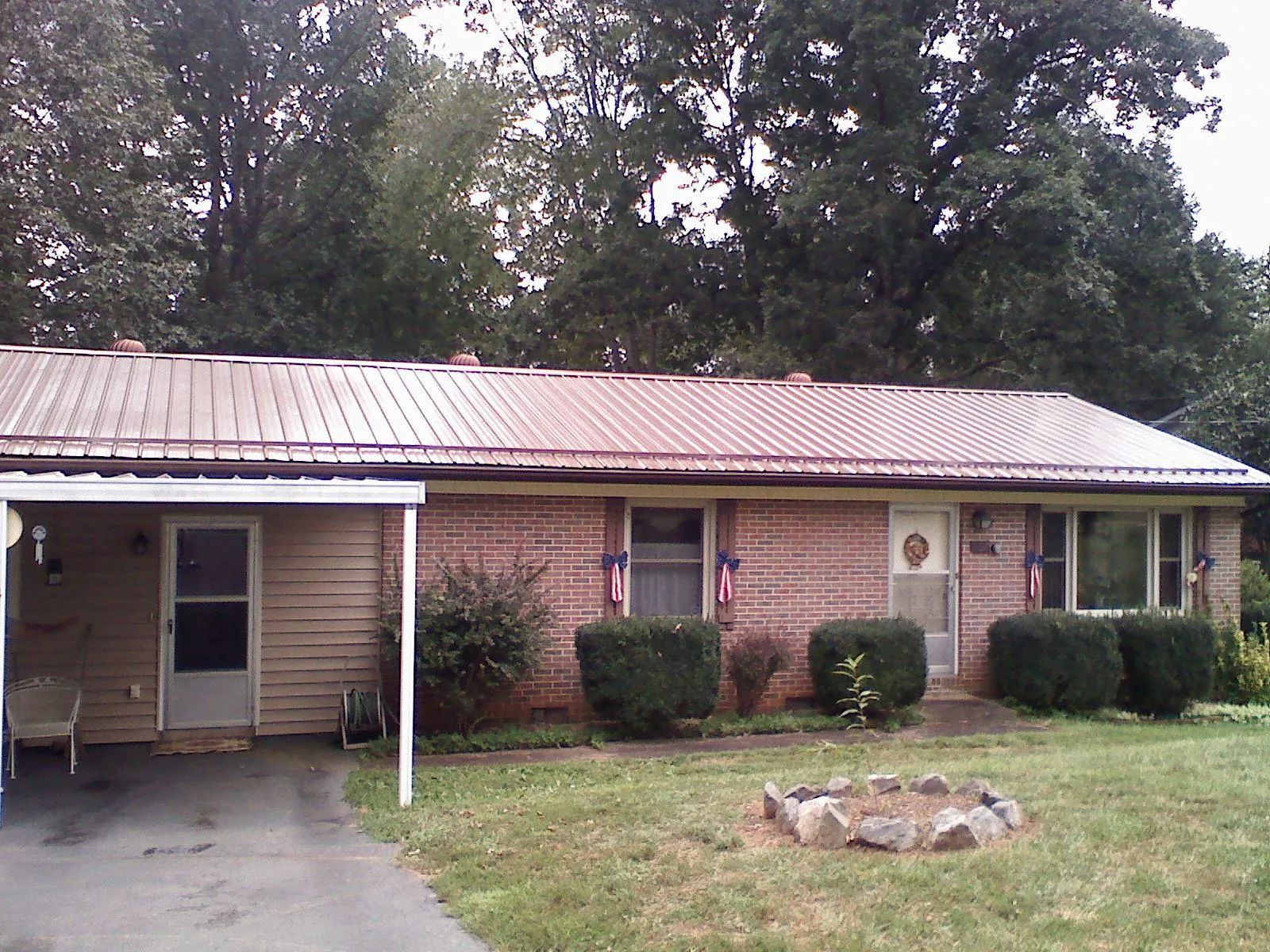 Bronze metal roof and carport on a brick ranch home — Roof Repair work by our crew in Dillon
